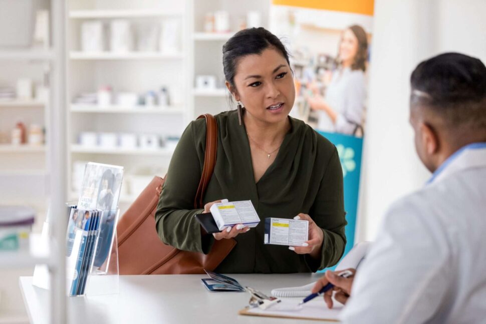 woman at pharmacy counter holding medicines